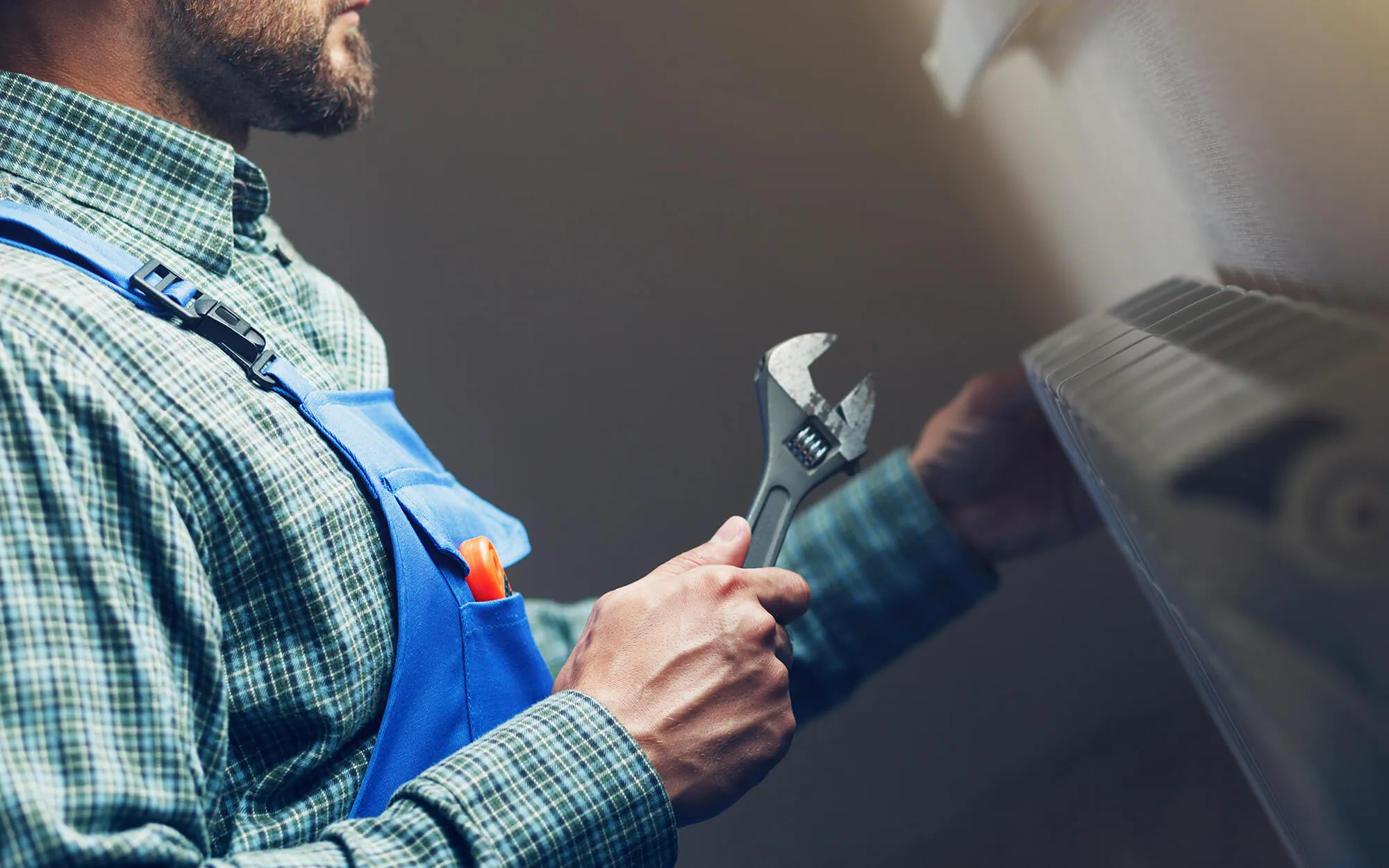 Handwerker mit Werkzeug vor einer Heizung
