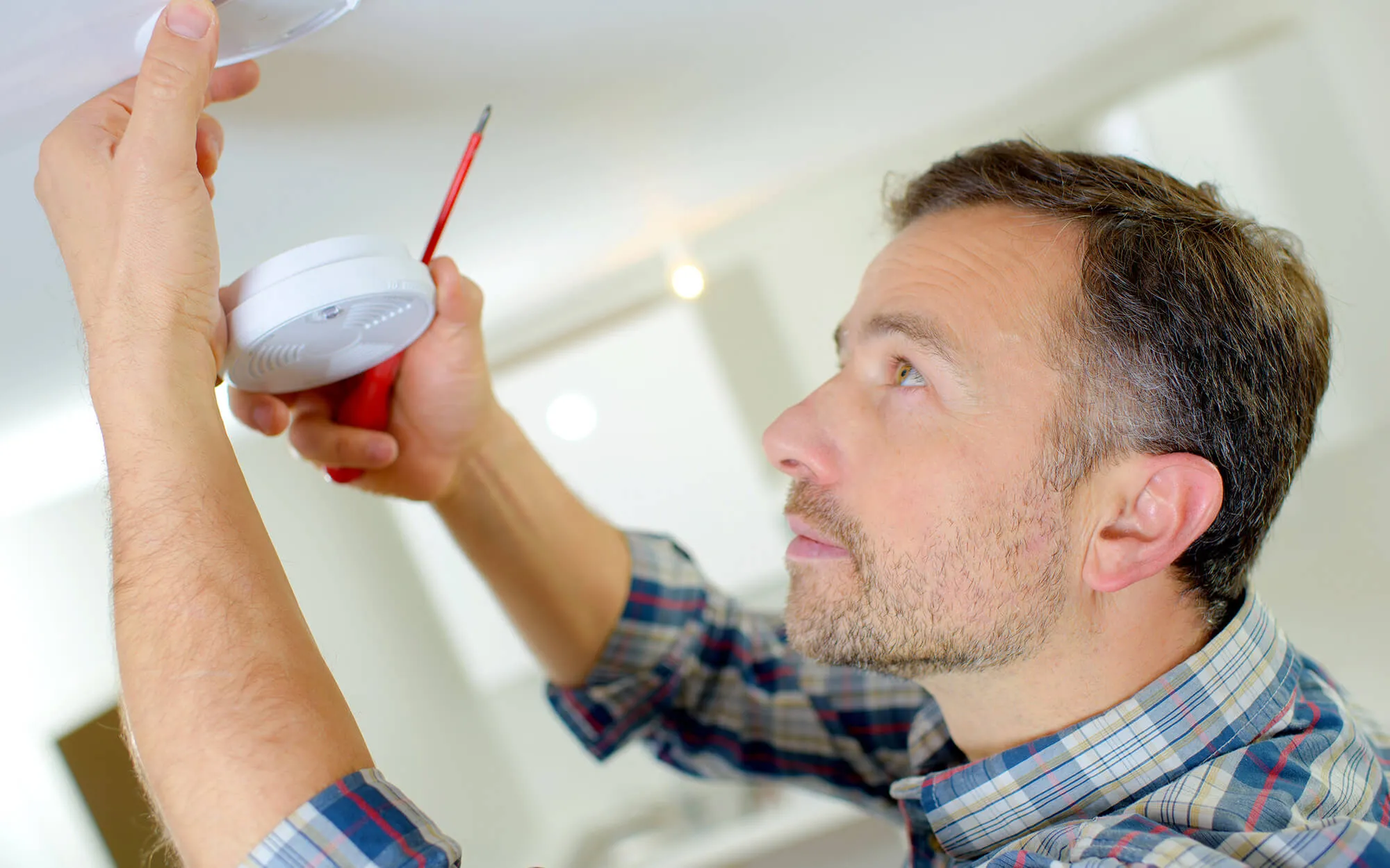 Handwerker, der einen Rauchwarnmelder installiert